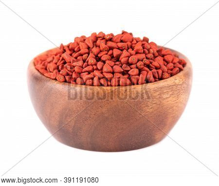 Annatto Seeds In Wooden Bowl, Isolated On White Background. Achiote Seeds, Bixa Orellana. Natural Dy
