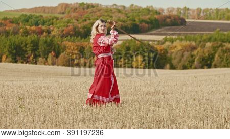 Training In The Autumn Field - A Belligerent Woman Wields With A Sword - Looking In The Camera