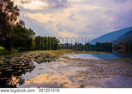 Blue Clouds Are Reflected On The Lake With Wooden Jetty On The Lakes Of Revine, Treviso, Veneto, Ita