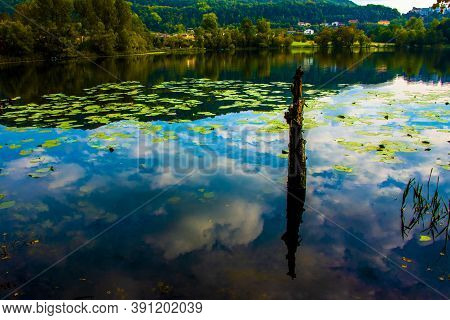 Blue Clouds Are Reflected On The Lake With Wooden Jetty On The Lakes Of Revine, Treviso, Veneto, Ita