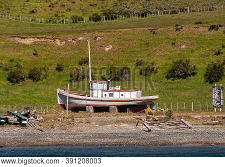 Riesco Island, Chile - December 12, 2008: Beached Old, Previously Painted Red And White, Boat Lies O