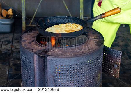 Oven, Fry Pancakes In A Cast-iron Black Pan. Cooking Pancakes On An Open Fire On An Iron Stove In Th