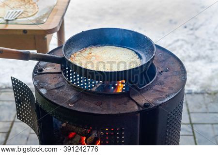 Oven, Fry Pancakes In A Cast-iron Black Pan. Cooking Pancakes On An Open Fire On An Iron Stove In Th