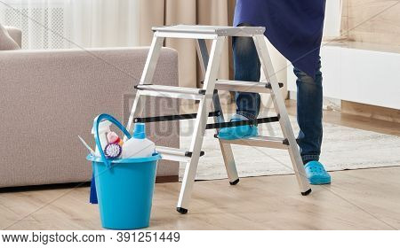Cropped View Of Man Climbing Ladder To Clean Ceiling. Cleaning Service Concept