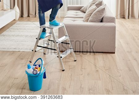 Cropped View Of Man Climbing Ladder To Clean Ceiling. Cleaning Service Concept