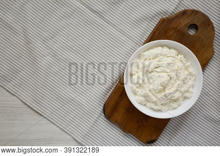 Tasty Ricotta Cheese In A White Bowl, Top View. Overhead, From Above, Flat Lay. Space For Text.