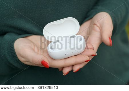 Young Girl Holds White Wireless Firo Vacuum Earbuds. Firo Is Wireless Technologies European Brand