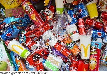 Many Wrappings And Cans From Used Products By Famous Worldwide Brands. Pattern Of Trash Of Various C
