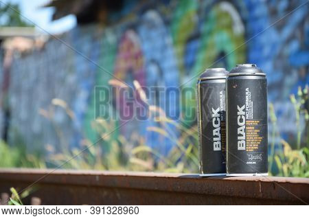 Used Montana Black Aerosol Spray Cans Against Graffiti Paintings. Mtn Or Montana-cans Is Manufacture