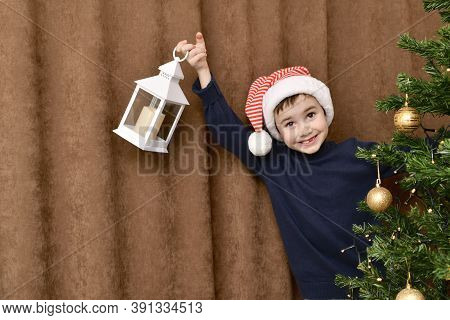 Smiling Kid, With An Enthusiastic Face, Suddenly Looked Out From Behind The Christmas Tree With A La