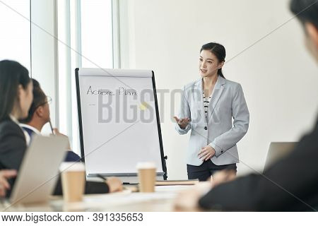 Young Asian Businesswoman Facilitating A Discussion During Team Meeting In Office