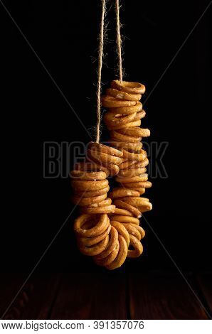 Bagels Hanging On A Rope On Black Background. Russian National Traditional Food.