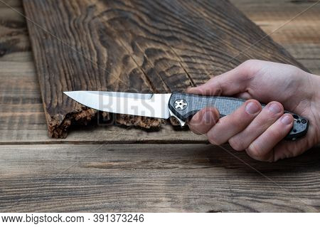 Knife With A White Blade In Hand. View Of The Knife In The Hand From The Side.