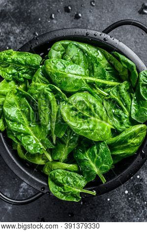 Fresh Spinach Leaves In A Colander. Black Background. Top View