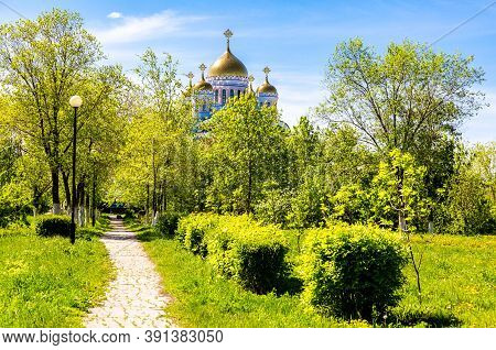 Golden Domes Of An Orthodox Church Among The Trees Of The City Park. Church Of Our Lady Of Tendernes