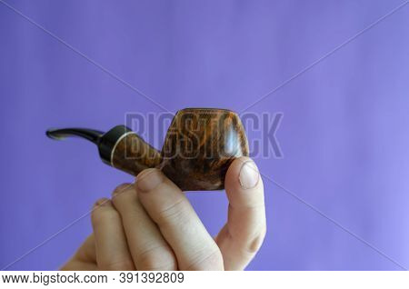 Briar Root Smoking Pipe In Hand. A Man's Hand Holds A Classic Smoking Pipe On A Blue Background. Sel