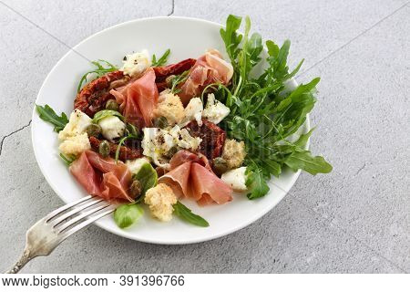 Salad Arugula, Parma Ham With Sun-dried Tomatoes, Mozzarella Slices, Croutons, Capers, Seasoned Oil 
