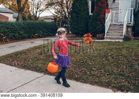 Trick Or Treat. Happy Child Girl With Red Pumpkin Basket Going To Trick Or Treat On Halloween Holida