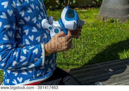 Cagnes-sur-mer, France. 16.10.2020 Cute Girl Playing With Interactive Toy. Child With Toy Robot Dog.