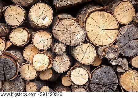 Firewood Pile, Pattern With Ends Of Logs Close-up. Woodpile Of Brown Timber, Stack Of Rough Sawn Tre