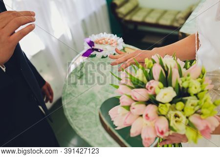 Newlyweds Exchanging Rings, Bride Putting The Ring On The Grooms Hand In Marriage Registry Office.