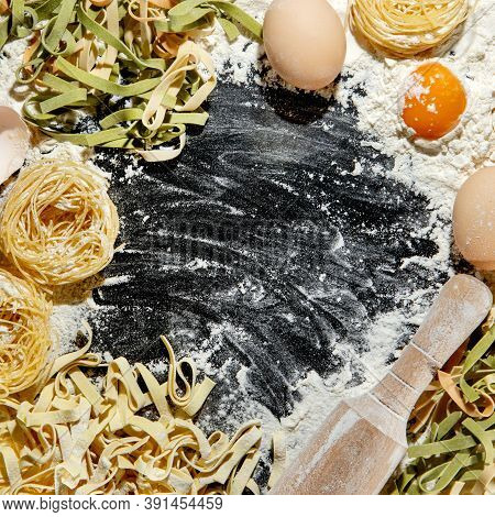 Freshly Cooked Pasta Is Lying On A Dark Surface Dusted With Flour. Italian Pasta. Tagliatelle. Raw P