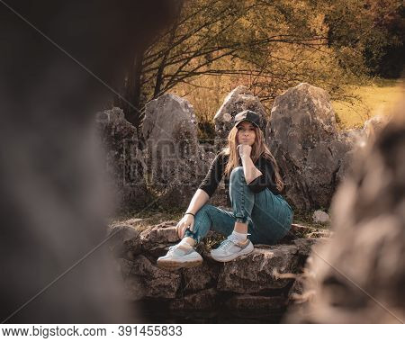 Zoomed Full Body Portrait Of An Attractive Brunette Sitting On A Well At The Rajcica Wells Natural L