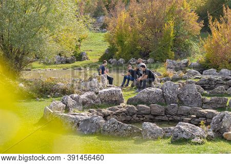 Split Croatia October 2020 A Group Of Friends Sitting Around On Rocks And Having Fun Talking And Rel