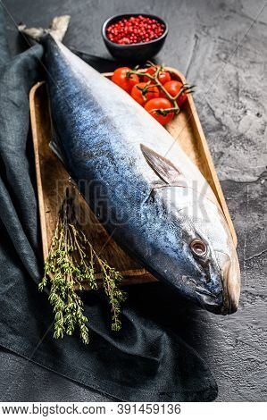 Fresh Whole Raw Japanese Yellowtail With Tomato And Herbs. Fish Amberjack. Black Background. Top Vie