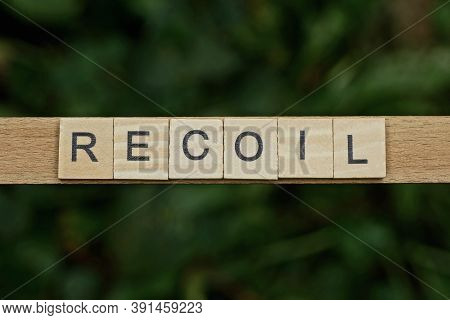 Gray Word Recoil Made Of Wooden Square Letters On Green Background