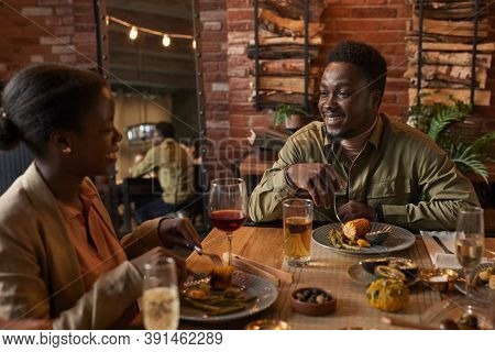 Portrait Of Young African-american Man Smiling At Girlfried While Enjoying Dinner Party Outdoors