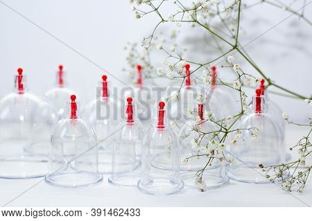 Jars For Hijama On A White Wooden Background And White Flowers. Bloodletting. Sunnah Treatment. Isla
