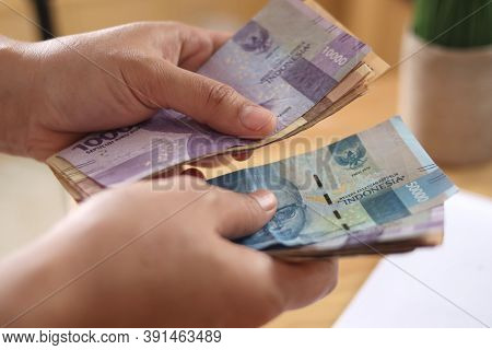 Close Up Of A Person Counting Money, Uang Indonesian Rupiah, Cash In Hand Concept