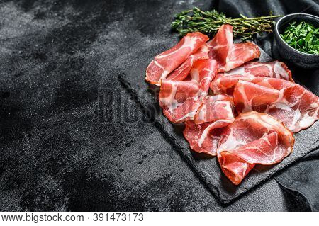 Italian Rolled Bacon Pancetta Piacentina. Pork Meat. Black Background. Top View. Copy Space