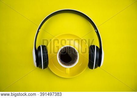 Top View Of Yellpw Coffee Cup With Headphone On Yellow Paper Background