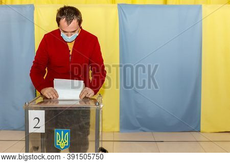 Velyka Dobron, Ukraine - October 25, 2020: Voter Wearing Protective Mask Votes In Local Elections Du