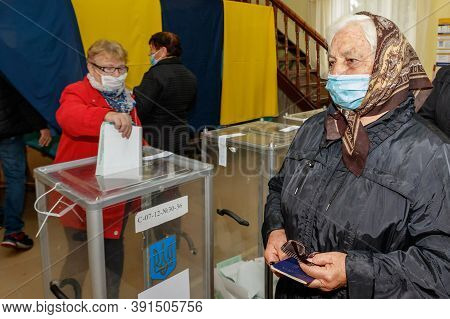 Velyka Dobron, Ukraine - October 25, 2020: Voters Wearing Protective Masks Vote In Local Elections D