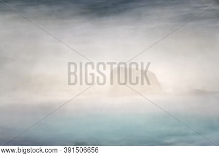 Rock In The Surf With Breaking Waves All Around It. Slow Shutterspeed Creating Dreamy, Misty Athmosp