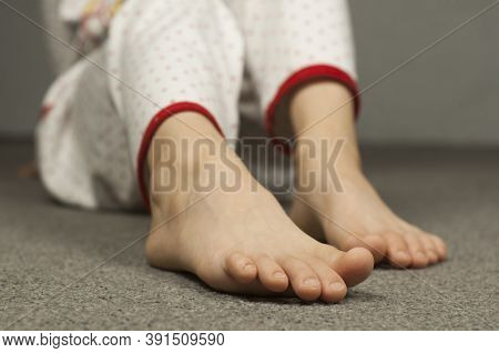 Legs Of A Child 8-10 Years Old In Pajamas. Foot