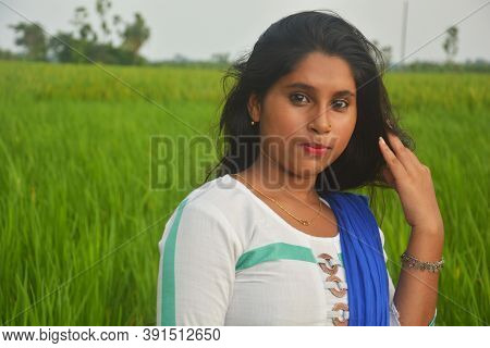 Close Up Of Teenage Girl Wearing Golden Nose Pin And Ear Rings With White Cotton Salwar Kameez Stand