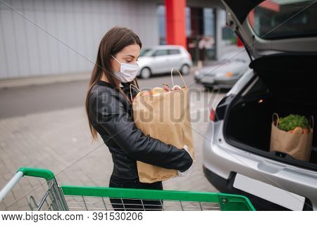 Groceries In Females Hand By The Car Truck. Woman In Protective Mask And Disposable Gloves. Fresh Fr