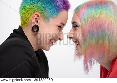 Young Lesbian Woman Couple With Vivd Colored Short Hair And Jackets Posing On White Background. Pier