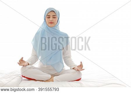 Close Up Young Asian Arab Woman Sitting On Bed And Enjoying Meditation. Beautiful Muslim Girl In Sle