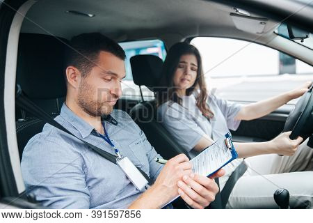 Upset Woman Failed Driving Exam Bites Lips And Worries About It. Male Instructor Notice Results Of T