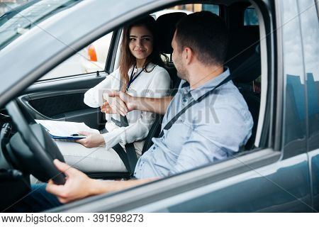 Female Auto Instructor Shaking Hands With Male Student. Attractive Woman Congratulates With Successf