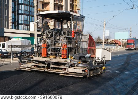 Industrial Asphalt Paver Machine Laying Fresh Asphalt On Road Construction Site On The Street. A Pav
