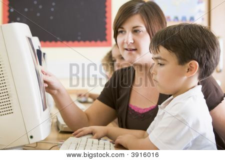 Insegnante di aiutare i bambini a studiare in aula computer