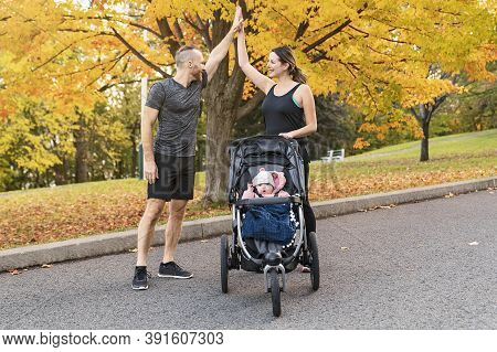 A Jogging Couple With Stoller On Autumn Season