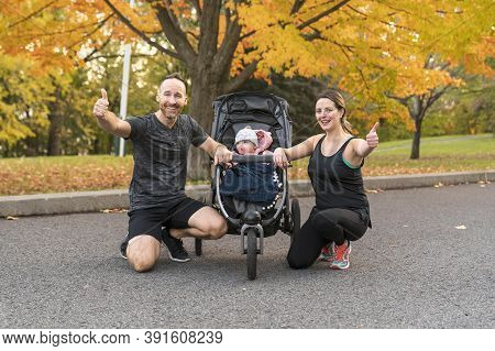 A Jogging Couple With Stoller On Autumn Season