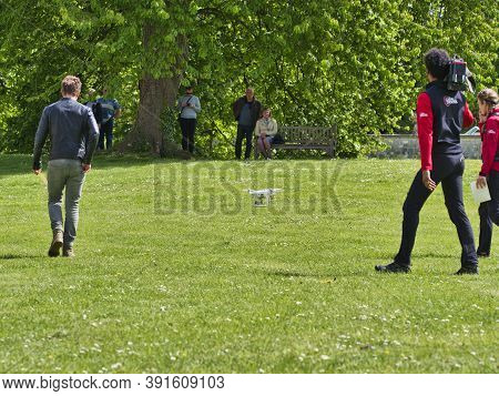 Jumieges, France - June Circa, 2019. Mature Male Technicians Outdoor, On Grass, Using Professional D